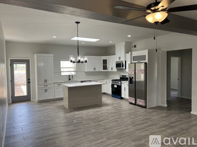 A modern kitchen with a large island and stainless steel appliances.