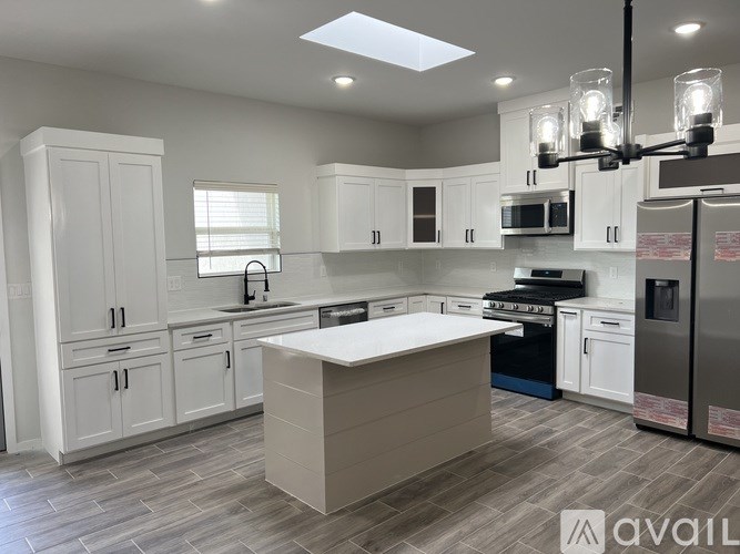 A modern kitchen with white cabinets and a central island.