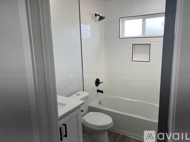 A white bathroom with a toilet, sink, and bathtub.