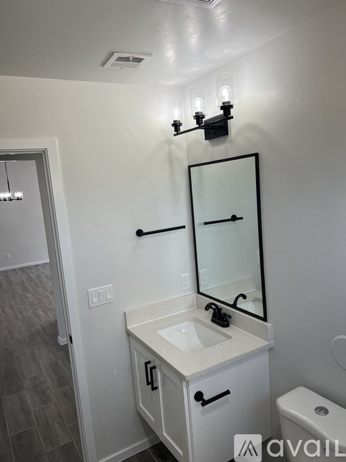 A bathroom with a sink, mirror, and toilet.