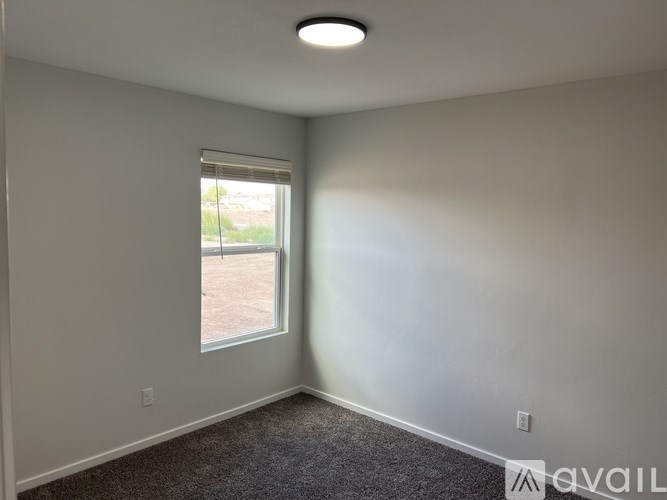 A room with a window and a carpeted floor.