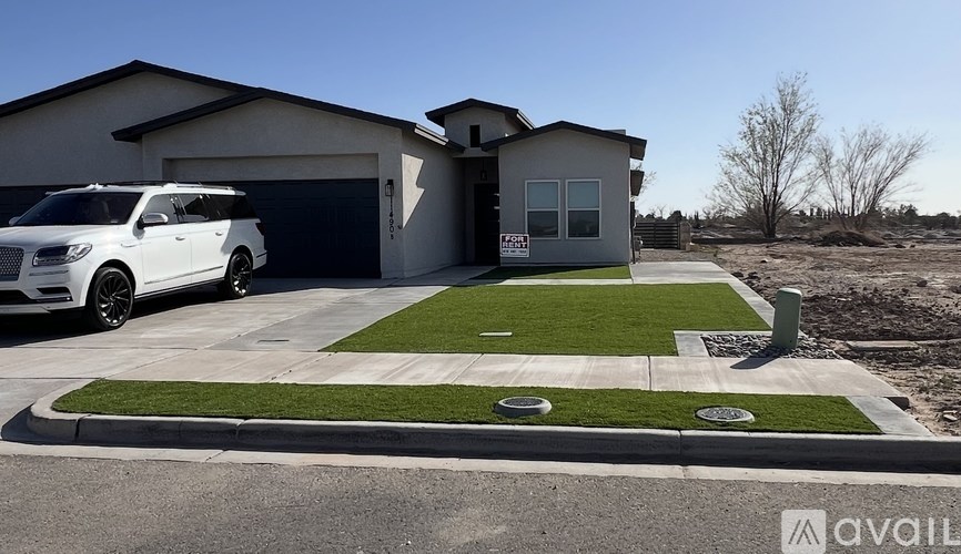 A white SUV is parked in front of a two-story house with a garage.