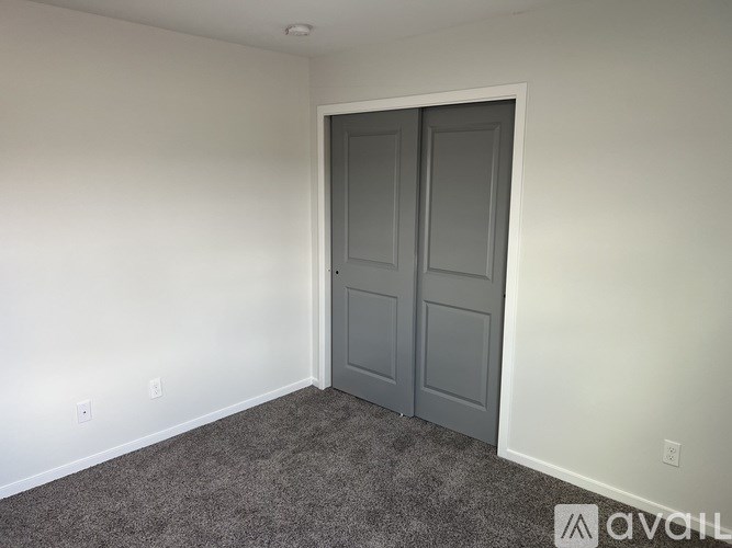 A room with a grey carpet and a grey door.