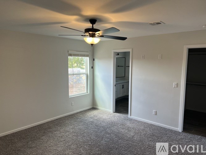 A room with a ceiling fan and a window.