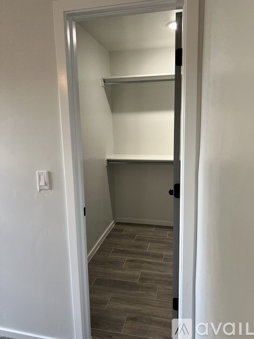 A small white closet with a shelf and a light switch.