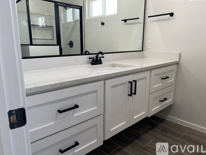 A bathroom with a white countertop and cabinets.