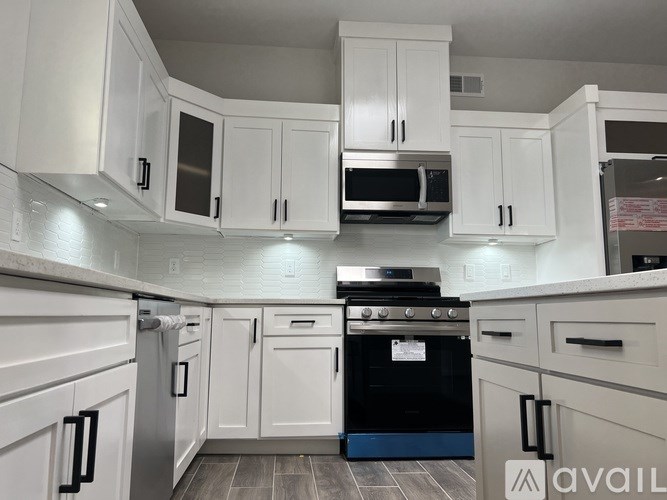A kitchen with white cabinets and a black oven.