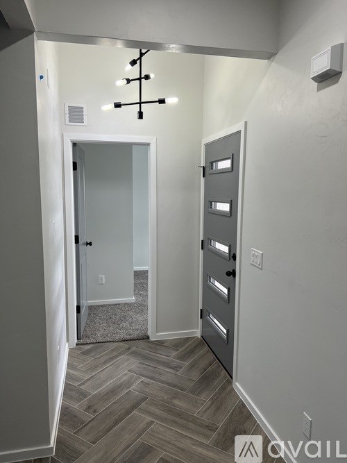 A hallway with a closed door and a light on the wall.