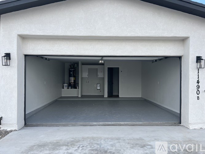 A garage with a white wall and a black door.