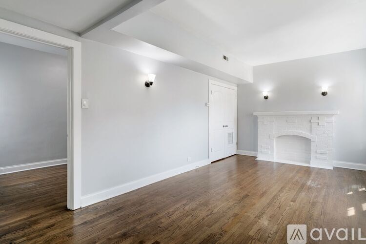 A room with a fireplace and wooden floors.
