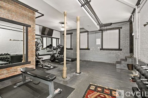 A gym with a bench, weights, and exercise equipment.