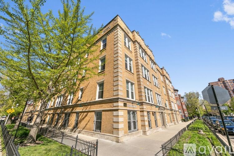 A tall brick building with a tree in front of it.