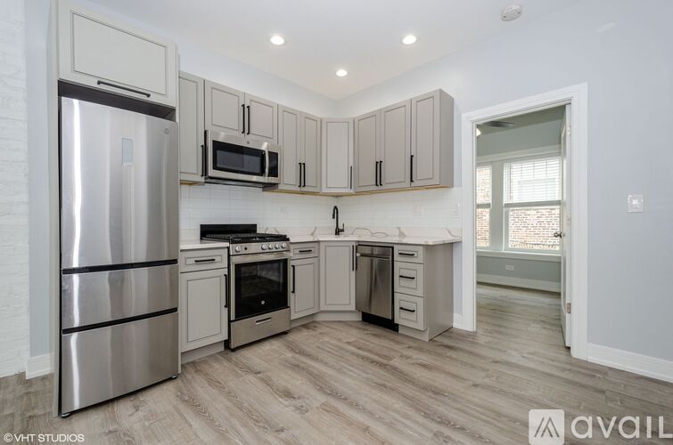A kitchen with a refrigerator, oven, microwave, and cabinets.