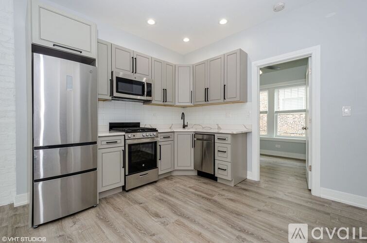 A kitchen with a refrigerator, oven, microwave, and cabinets.
