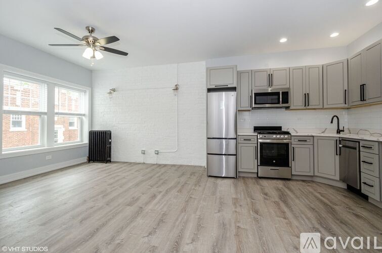 A kitchen with a refrigerator, microwave, oven, and sink.