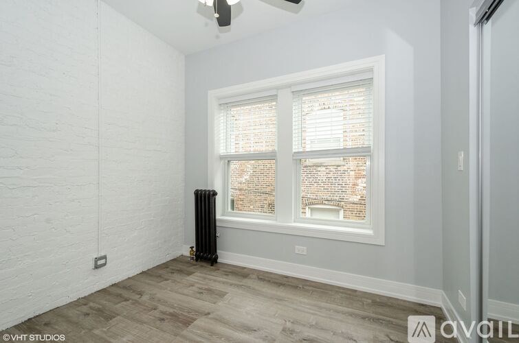 A room with a window and a radiator on the floor.
