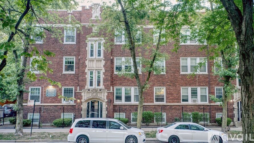 A red brick building with a white car parked in front.
