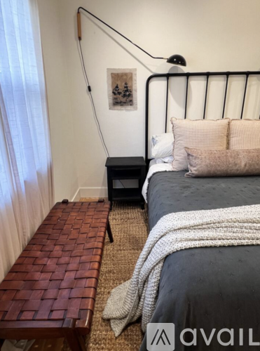 A bedroom with a large bed and a mirror on the dresser.