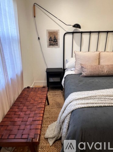 A bedroom with a large bed and a mirror on the dresser.