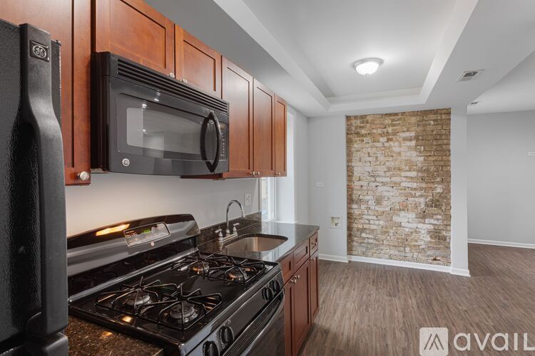 A spacious room with wooden floors and two windows.
