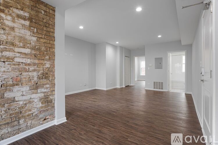 A large empty room with wooden floors and white walls.