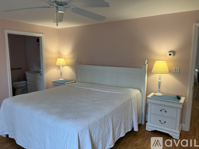 A bedroom with a bed, nightstand, and two lamps.