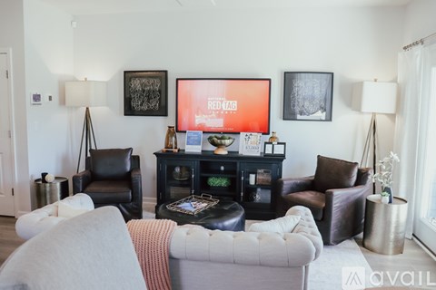 A living room with a grey couch and a black chair.