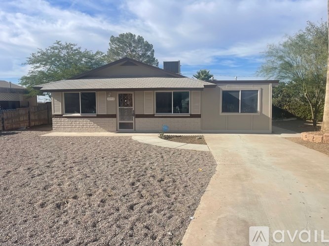 A house with a grey roof and a brown garage door is available for rent.
