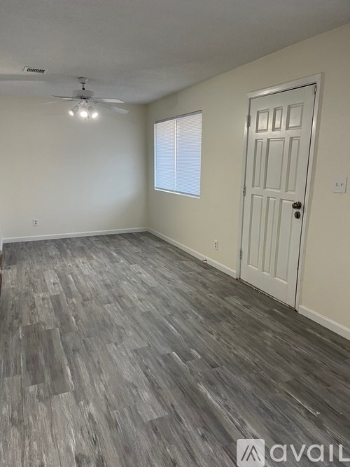 A room with a white door and a ceiling fan.