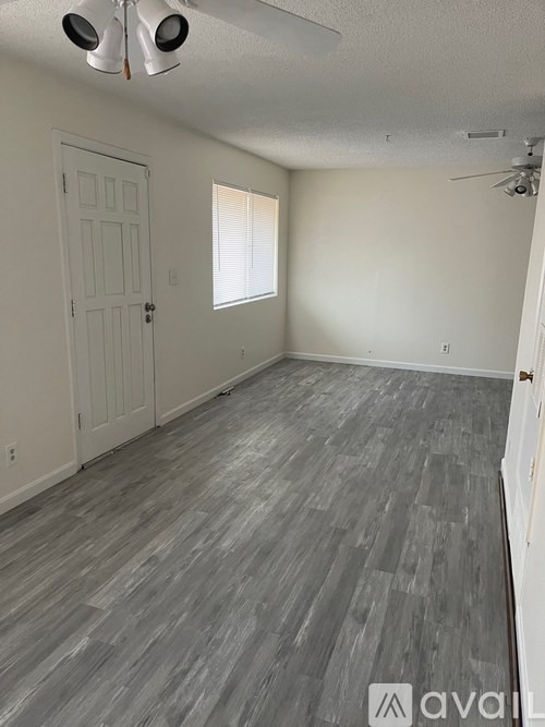 A room with a grey floor and a white door.