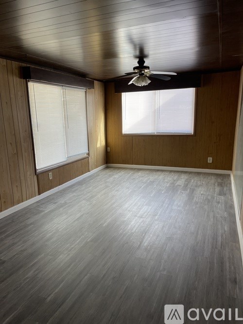 A room with wooden walls and a ceiling fan.