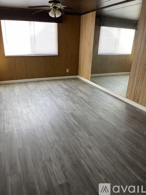 A room with wooden flooring and a ceiling fan.
