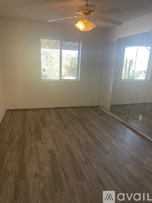 A room with wooden flooring and a ceiling fan.