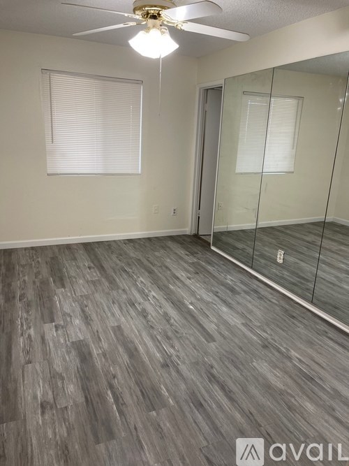 A room with a wooden floor and a glass door.