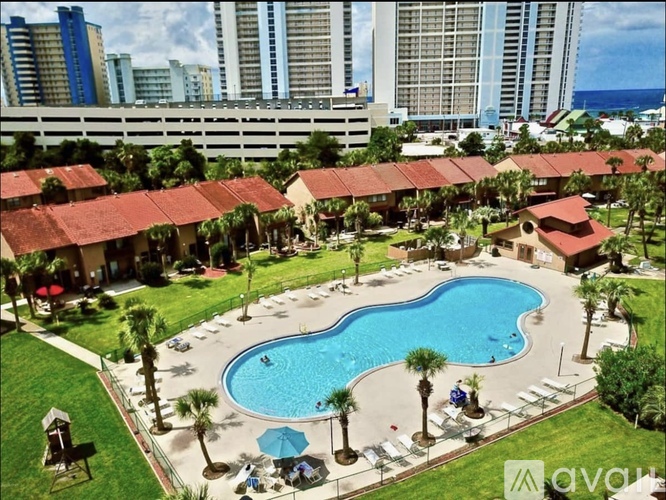 A pool surrounded by palm trees and umbrellas.