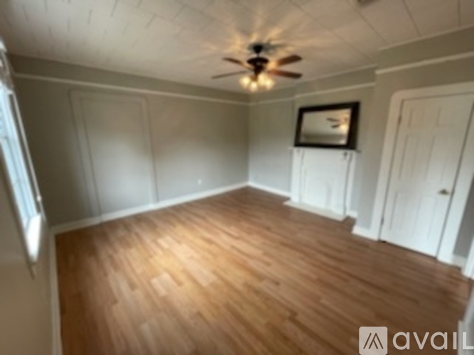 A room with wooden flooring and a ceiling fan.
