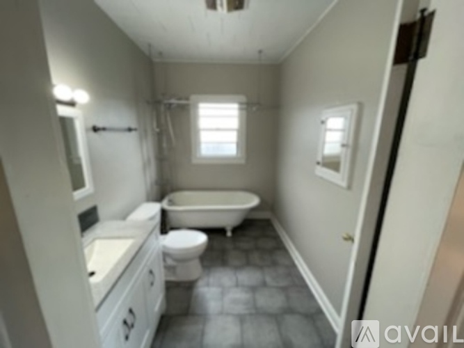 A bathroom with a tub, toilet, and sink.