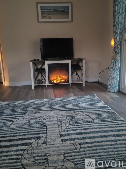 A living room with a television and a fireplace.