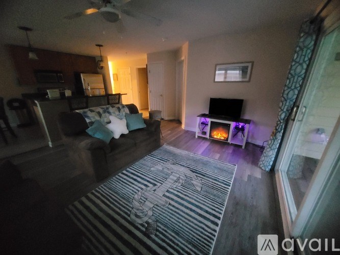 A living room with a fireplace and a rug on the floor.