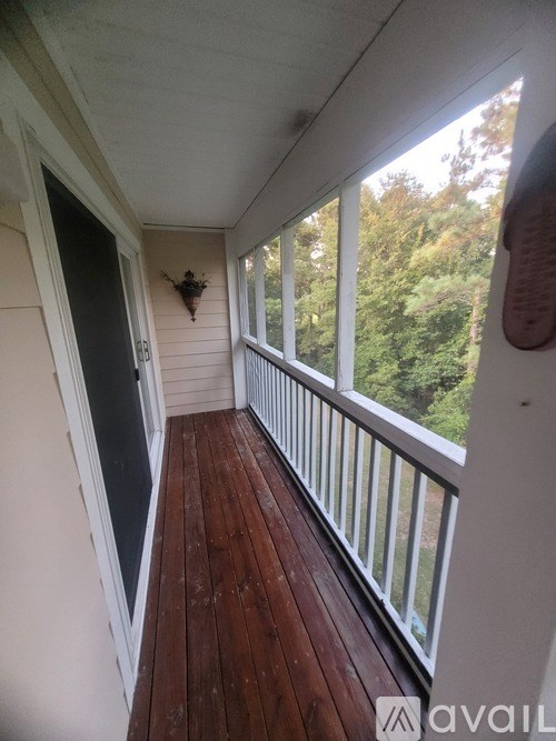 A balcony with a white railing and wooden floor.
