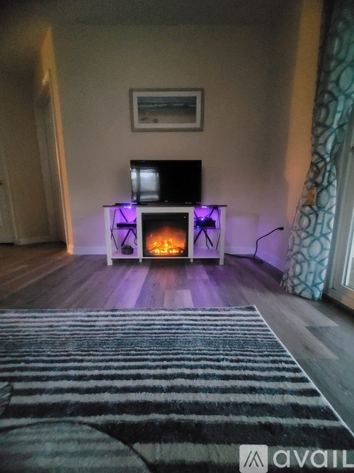 A modern living room with a fireplace and a television.