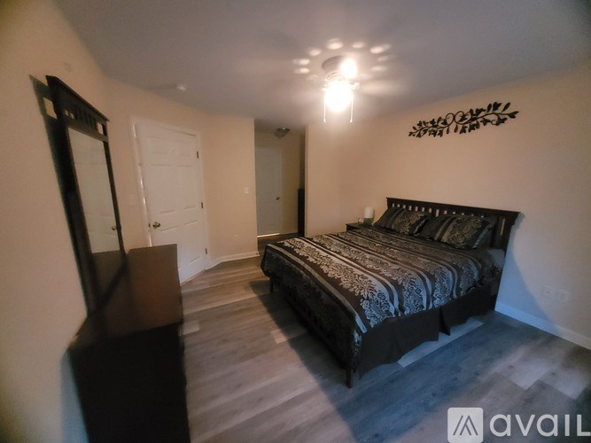 A bedroom with a bed, dresser, and mirror.