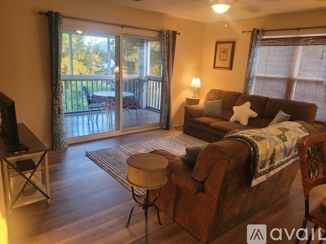 A living room with a brown couch and a television.