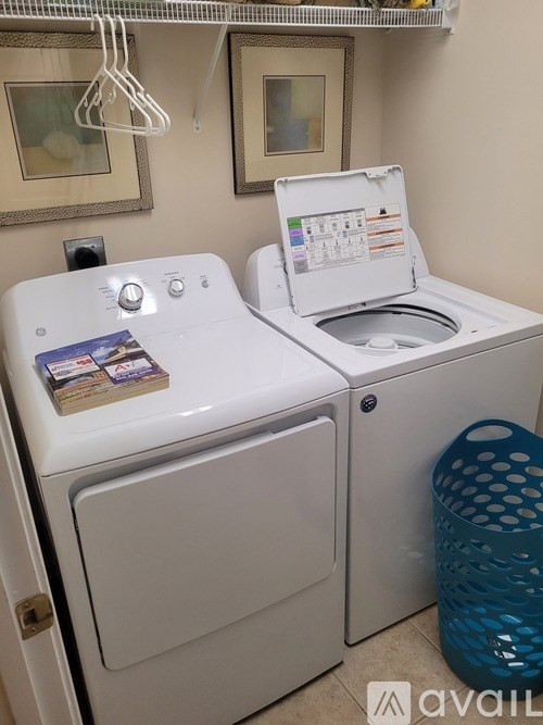 A small white washing machine with a book on top of it.