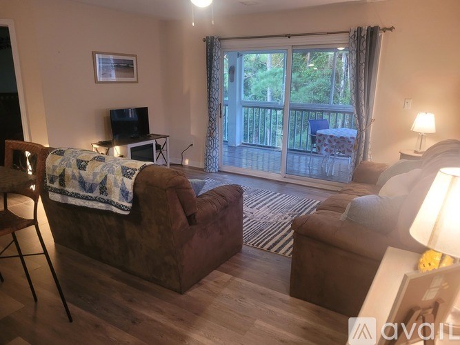 A living room with a couch, chair, and television.