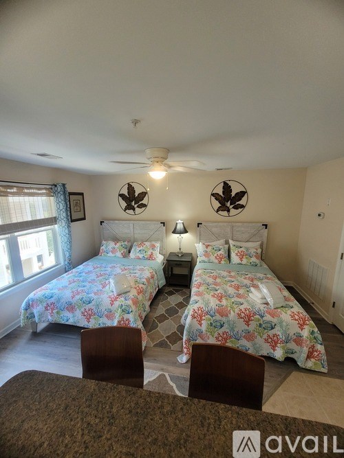 A bedroom with two beds and a ceiling fan.