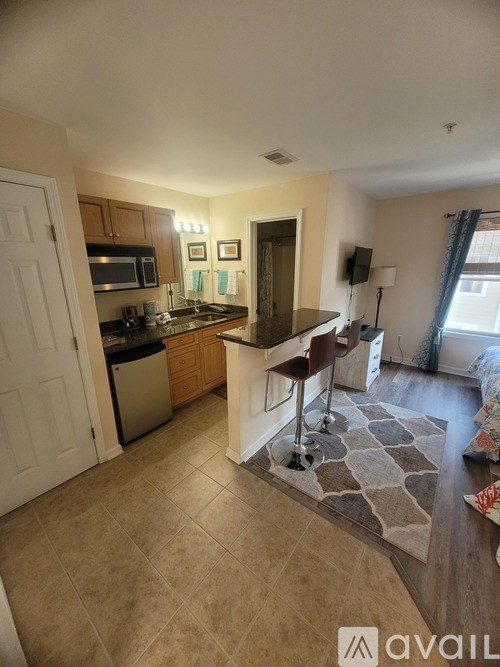 A kitchen with a bar stool and a counter.