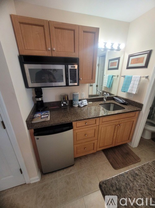 A kitchen with wooden cabinets and a granite countertop.