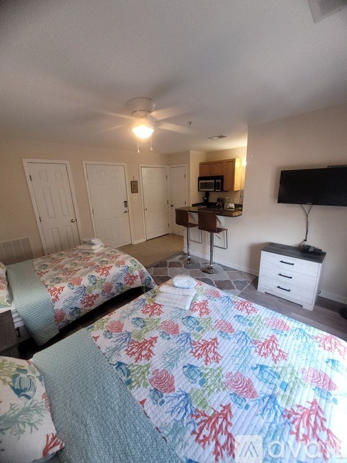 A bedroom with two beds and a television.