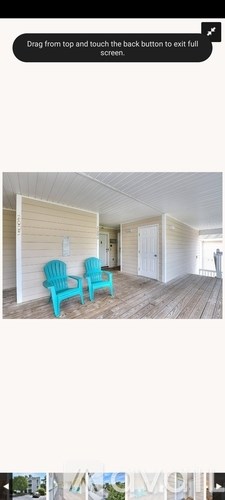 Two blue chairs are placed on a wooden deck.